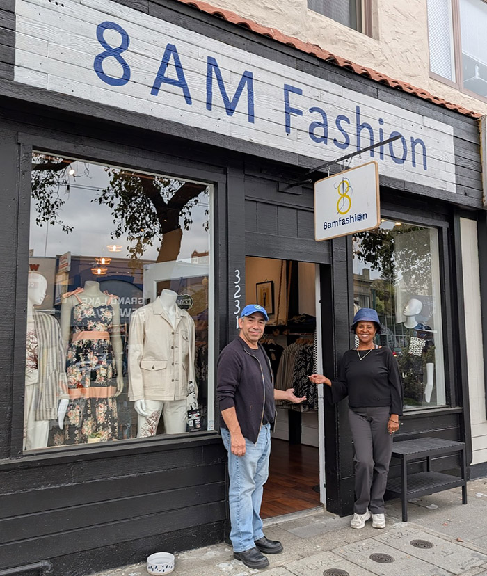 Man and woman in front of 8 AM Fashion storefront