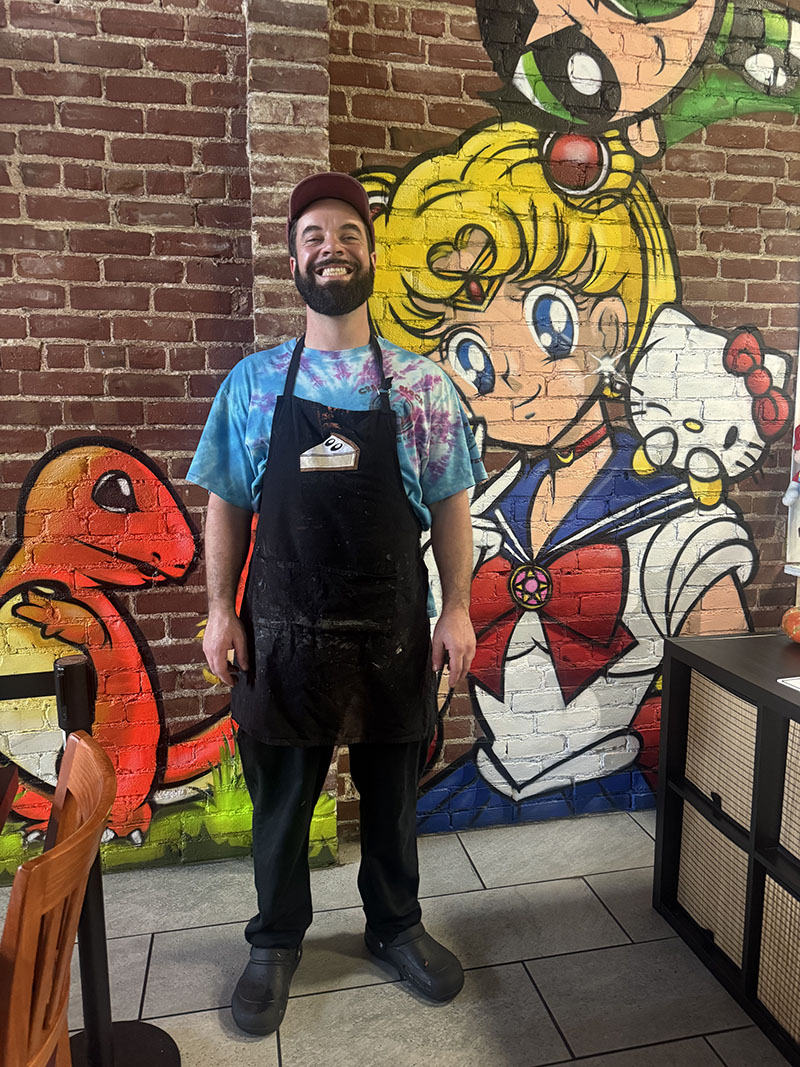 Ben Block in restaurant in front of sailor moon cartoon mural on brick wall