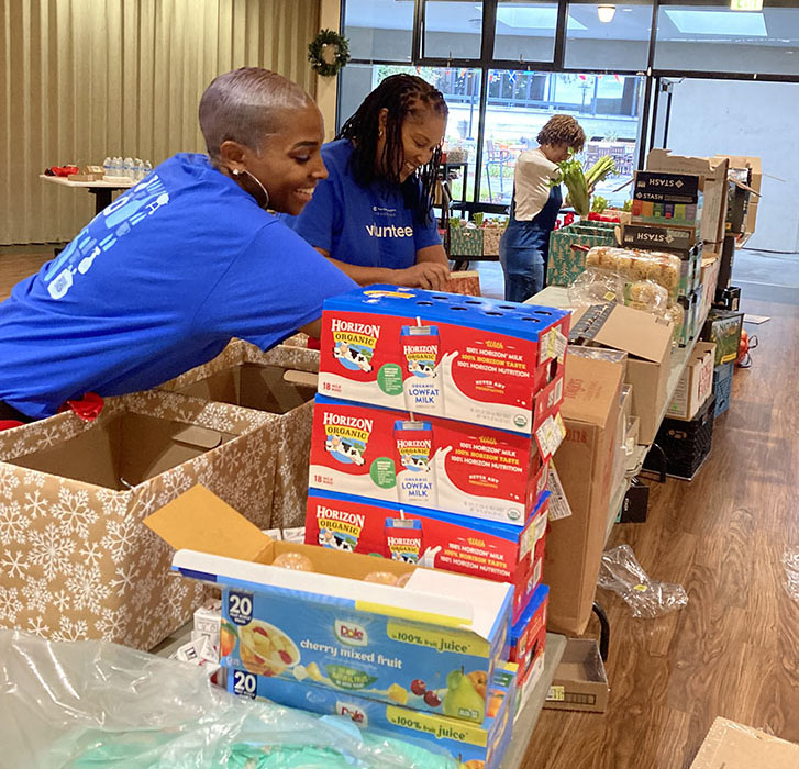 Three volunteers fil holiday boxes